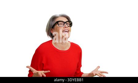 Donna anziana che reagisce con sorpresa guardando in alto Foto Stock