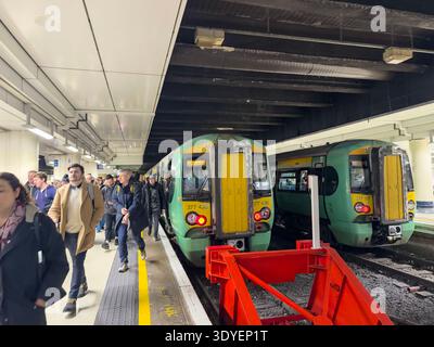 Treno ai binari e passeggeri in una stazione Victoria di Londra, Westminster, Londra, Inghilterra, Regno Unito Foto Stock
