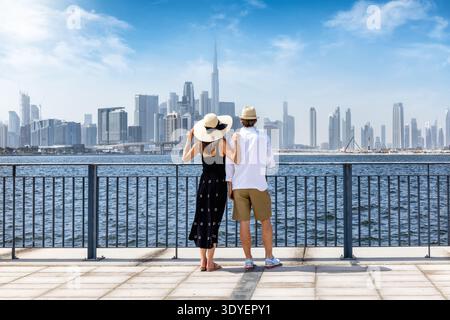 Una bella coppia di turisti in gita turistica gode della vista dello skyline di Dubai, Emirati Arabi Uniti, come concetto di viaggio in città Foto Stock