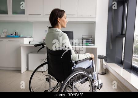 Donna paziente in sedia a rotelle seduta in sala esame medica Foto Stock