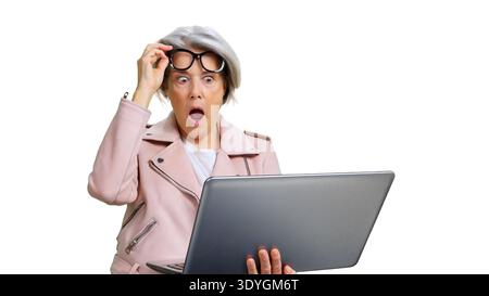 Donna anziana che reagisce con shock vedendo i contenuti del notebook Foto Stock