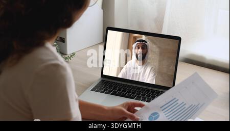 La donna si impegna in videocall con un uomo vestito con kandora tradizionale Foto Stock
