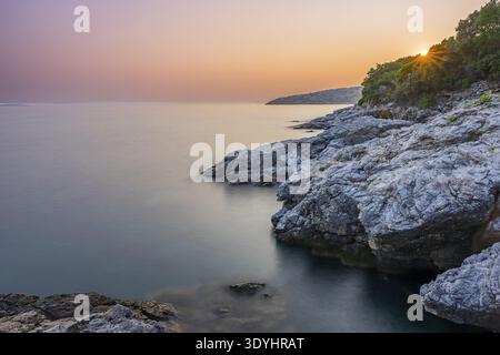 Acque cristalline e turchesi sulla spiaggia di Ustrine Bay in una giornata di sole al tramonto sull'isola di Cherso, lunga esposizione, Croazia Foto Stock