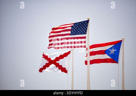 Le bandiere degli Stati Uniti, Porto Rico, e la storica Croce di Borgogna ondeggiano nella brezza sopra Castillo San Felipe del Morro nella vecchia San Juan Foto Stock