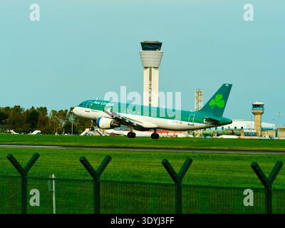 Dublino, Irlanda, 8 ottobre 2023. Un aereo passeggeri Aer Lingus Airbus A320 atterra su una pista all'aeroporto di Dublino in Irlanda. L'alta torre di controllo Foto Stock