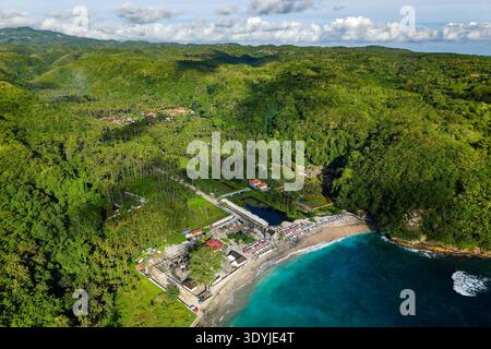 Vista aerea ad alto angolo di una vibrante spiaggia tropicale circondata da fitte palme verdi Foto Stock