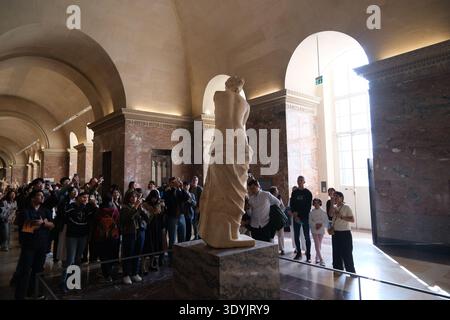 Parigi, Francia - 4 ottobre 2025: Folla di turisti che fotografano Venere di Milo all'interno del Museo del Louvre Foto Stock