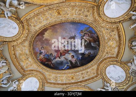 Parigi, Francia - 4 ottobre 2025: Vista ad angolo basso dell'intricato soffitto dorato e dell'affresco mitologico classico nella Galerie d'Apollon, Museo del Louvre Foto Stock