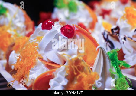 Crepes croccanti thailandesi con crema e condimento di foy in primo piano. Vivace dessert di strada che mostra consistenza e autentico sapore thailandese. Foto Stock