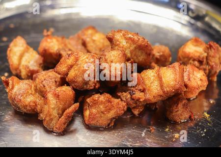Pancetta di maiale fritta croccante su vassoio di metallo che mostra una consistenza marrone dorata interni succosi e un autentico concetto di snack thailandese di Street food. Foto Stock