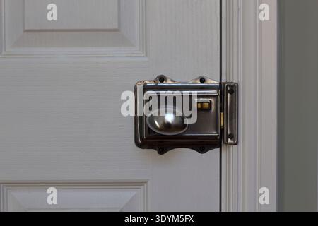 Una classica serratura su una porta bianca interna di una casa Foto Stock