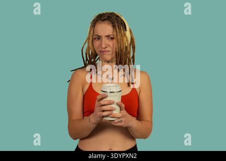 Donna che reagisce con disprezzo tenendo una tazza, sentendo scetticismo Foto Stock