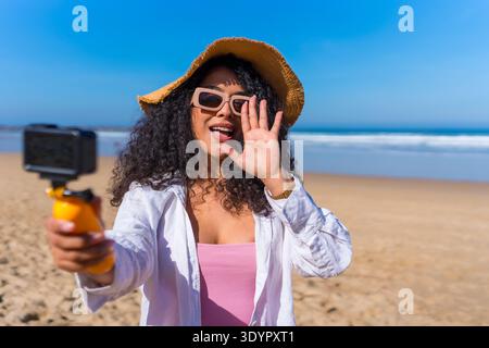Donna che registra contenuti influencer sulla spiaggia Foto Stock