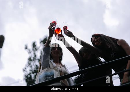 Amici che brulicano bicchieri di vino rosso e rosato contro un cielo luminoso al Festival del vino di Yerevan. Foto Stock