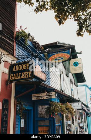 Le colorate vetrine fiancheggiano una strada piovosa nel centro di Bar Harbor, Foto Stock