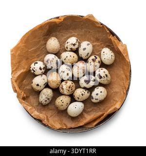 Uova di pasqua di quaglia nella ciotola su pergamena marrone Foto Stock