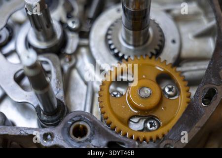 Vista ravvicinata dettagliata di un intricato meccanismo di trasmissione del motore di una motocicletta durante la riparazione o la manutenzione, che mostra parti interne complesse e. Foto Stock