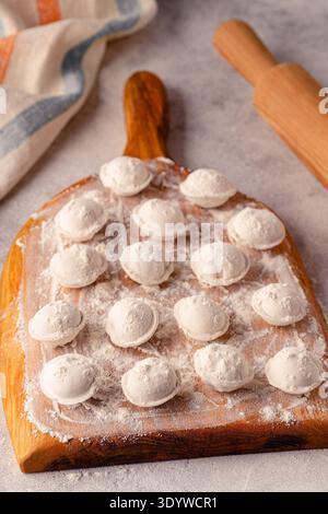 Gnocchi crudi fatti in casa sulla tavola. Il processo di preparazione degli alimenti. Foto Stock