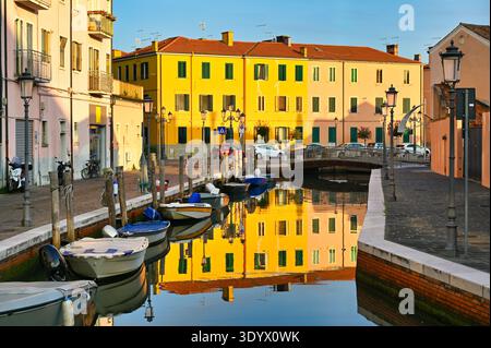 Vecchio edificio giallo riflesso nel canale, Chioggia, Italia Foto Stock