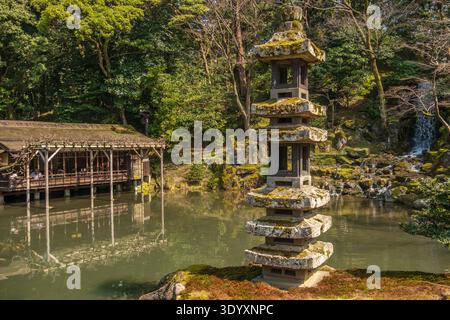 Tradizionale casa da tè giapponese, lanterna in pietra e cascata nel Giardino Kenrokuen, Kanazawa, Giappone. Foto Stock