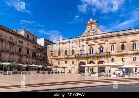 Vista soleggiata su Palazzo San Francesco, il Municipio, in Piazza della Libertà, Ostuni. L'architettura neoclassica in pietra locale si erge sotto un blu Foto Stock