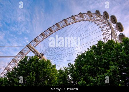 Ruota panoramica del London Eye che si innalza sopra gli alberi lungo il fiume sullo skyline di South Bank, Londra, Inghilterra, Regno Unito Foto Stock