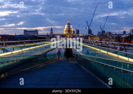 St Paul's Cathedral viewed along Millennium Bridge at dusk with illuminated walkway leading across the River Thames, London, England, United Kingdom Foto Stock
