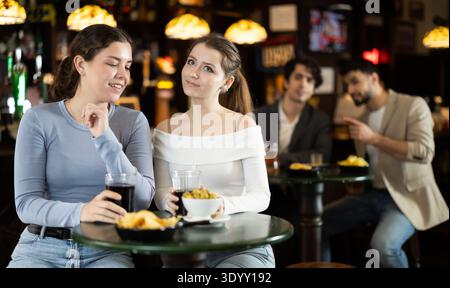 Due giovani donne che chiacchierano e bevevano birra al bar Foto Stock