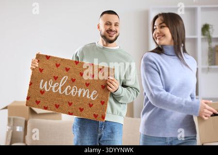 Giovane coppia con tappetino in camera il giorno del trasloco Foto Stock