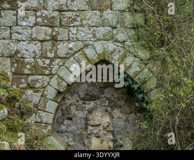 Arco medievale del monastero con pietra calcarea intemprata Foto Stock