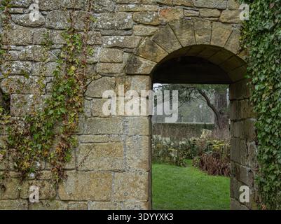 Arco medievale del monastero con pietra calcarea intemprata Foto Stock