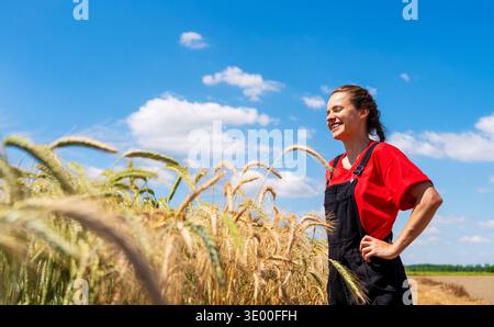 Ritratto sincero di un'agricoltrice in campo agricolo in estate. Foto Stock