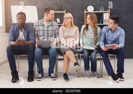 Gruppo di uomini d'affari seduti su sedie Foto Stock
