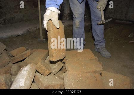 Mason costruisce un muro di mattoni, lavori di costruzione in un cantiere Foto Stock