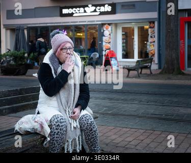 Signora anziana che fuma a Limmerstrasse, Hannover, Germania Foto Stock