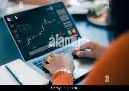Primo piano di una donna trader che utilizza un laptop per l'analisi del mercato azionario e il trading online. Concetto di investimento finanziario, cambio forex, criptovaluta gr Foto Stock