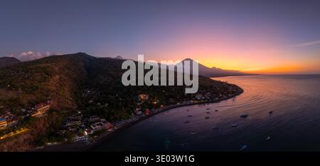 Vista panoramica della costa con droni e profilo del vulcano al tramonto a Bali. Foto Stock
