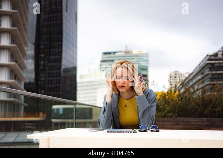Donna d'affari che soffre mal di testa e stress all'aperto in città Foto Stock