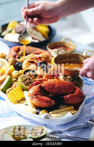 Un delizioso piatto gourmet di pesce con granchi e gamberi freschi, accompagnato da una gustosa salsa fatta a mano. Una festa per i sensi con vibrante Foto Stock