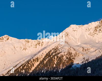 Luna piena che sorge sulle Dolomiti italiane al tramonto invernale, vista terra Foto Stock