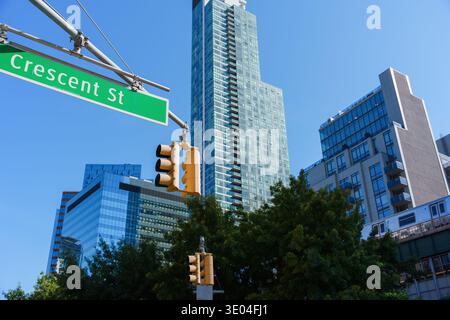 New York, Stati Uniti - 2 settembre 2023: Segnale stradale e semafori all'incrocio di Crescent Street con i moderni grattacieli di Long Island City Foto Stock