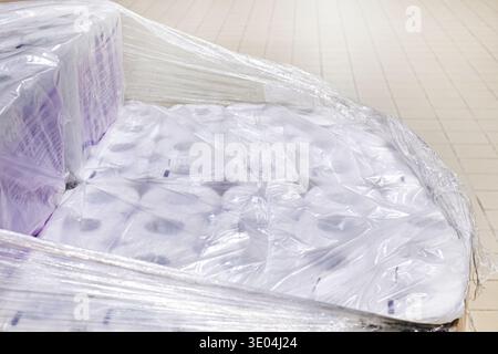 Rotoli di carta igienica avvolti in pellicola trasparente in un contenitore in un supermercato Foto Stock