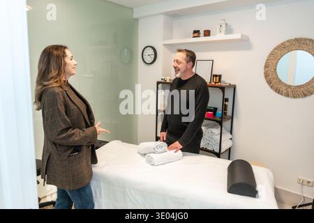 Cliente che parla con un massaggiatore professionista nel centro benessere Foto Stock