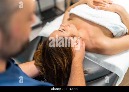 Donna che riceve un massaggio rilassante al collo dal massaggiatore Foto Stock