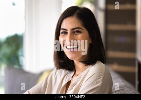 Allegra bella bruna giovane donna latina che posa a casa Foto Stock