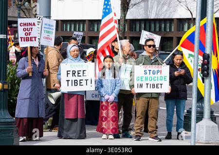Portland, Oregon, Stati Uniti. 10 marzo 2026. I manifestanti hanno dei cartelli che recitano "la Cina fuori dal Tibet", "i diritti umani in Tibet e in Cina", "Tibet libero" e "Stop Genocide in Tibet" durante una marcia del giorno della rivolta tibetana organizzata dall'Associazione culturale tibetana nordoccidentale. Sullo sfondo è visibile una bandiera statunitense. Crediti: Norboe Photo/Alamy Live News Foto Stock