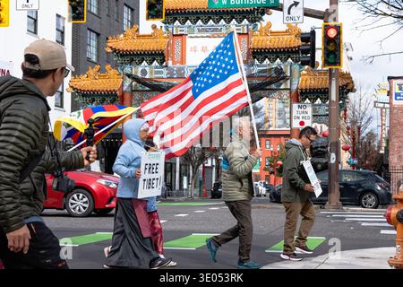 Portland, Oregon, Stati Uniti. 10 marzo 2026. I manifestanti portano una bandiera statunitense e un cartello "Tibet libero" mentre attraversano di fronte alla porta di Chinatown durante una marcia del giorno della rivolta tibetana organizzata dalla Northwest Tibetan Cultural Association. Crediti: Norboe Photo/Alamy Live News Foto Stock
