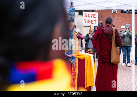 Portland, Oregon, Stati Uniti. 10 marzo 2026. Un monaco buddista si erge con le mani in una posizione di preghiera ad un tavolo cerimoniale drappeggiato con tessuti tibetani durante una manifestazione del giorno della rivolta tibetana nella Piazza del Pioneer Courthouse, organizzata dalla Northwest Tibetan Cultural Association. Sullo sfondo è visibile un segno "Save Tibet". Crediti: Norboe Photo/Alamy Live News Foto Stock