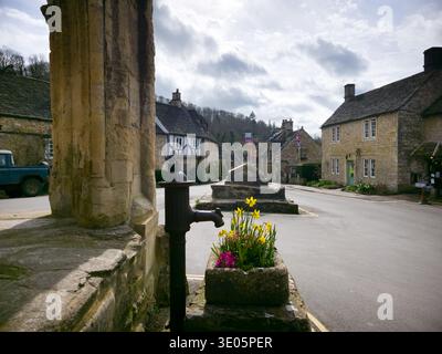 Castle Combe: Cieli nuvolosi sull'iconico Cotswolds Village in Inghilterra Foto Stock
