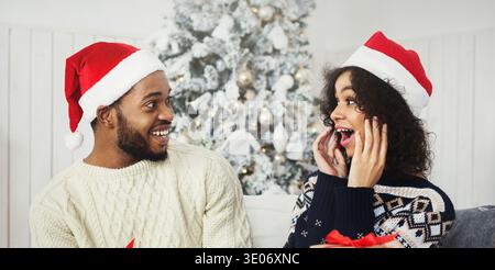 Coppia afroamericana sorpresa a ricevere regali di Natale Foto Stock